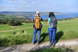 Walkers looking over a field out towards the sea