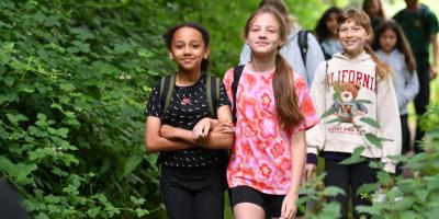 School residentials with YHA Group of smiling children walking through woodland