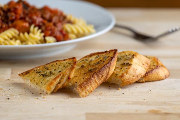 Slides of garlic bread and a bowl of pasta