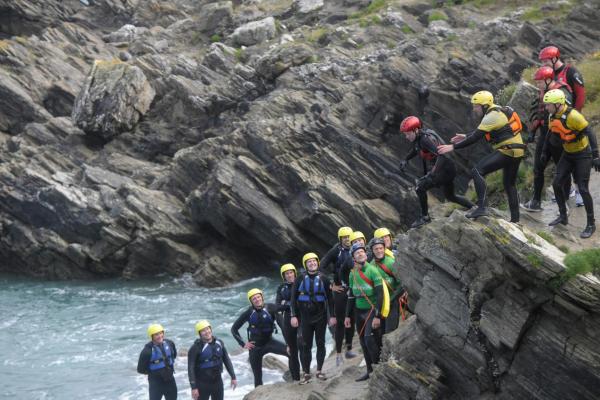 Group of people Coasteering on the Cliffs in Newquay, Cornwall