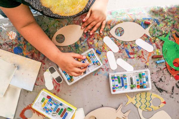 Child painting wooden fish