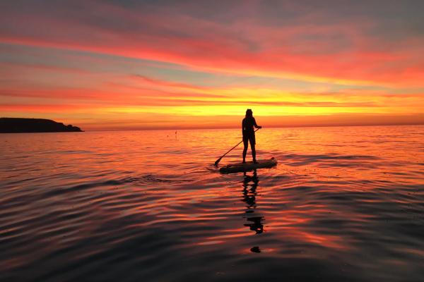 Person on a paddleboard at sunset