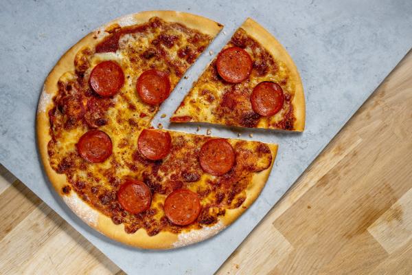 Pizza with a slice cut out on a stone board