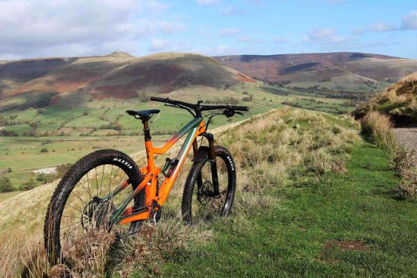 Orange bike in a field with a view of the countryside in the background