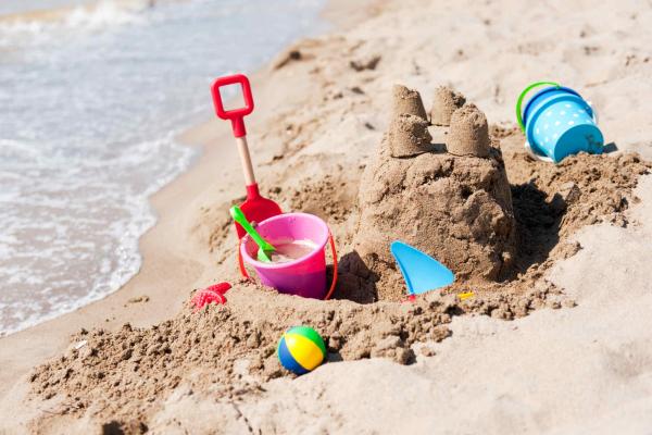 Bucket and spade next to a sandcastle on the beach