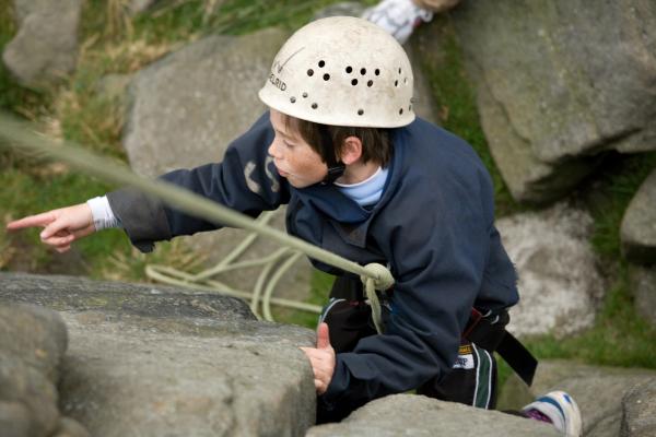 Boy abseiling down a rock face