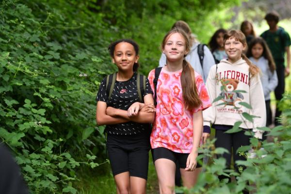 Group of smiling children walking through woodland