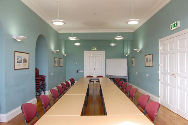 Room with blue painted walls and tables surrounded by red chairs