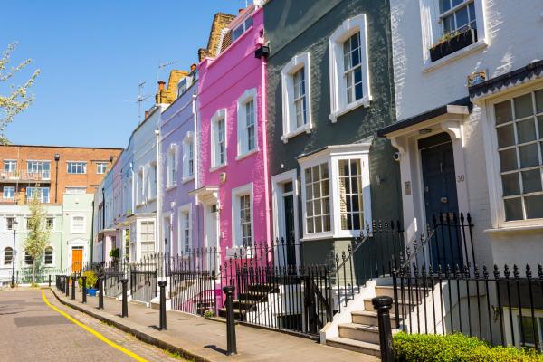 Row of terraced houses painted in different shades of pink, purple and blue