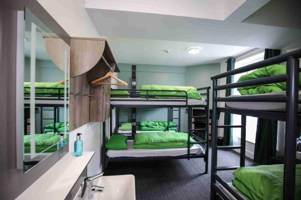 Large bedroom with bunk beds and a mirror over a washbasin