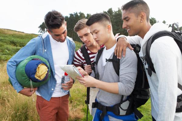 Group of young people reading a map on university trip