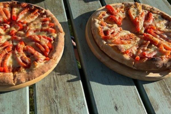 Two pizzas on a wooden table