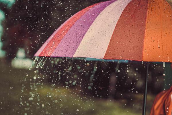 Raindrops falling on a colourful umbrella