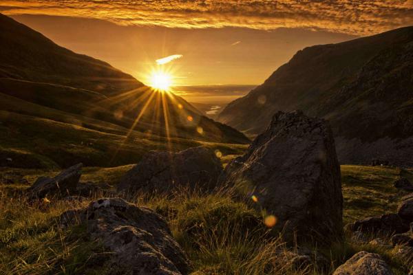 Sun rising over countryside hills