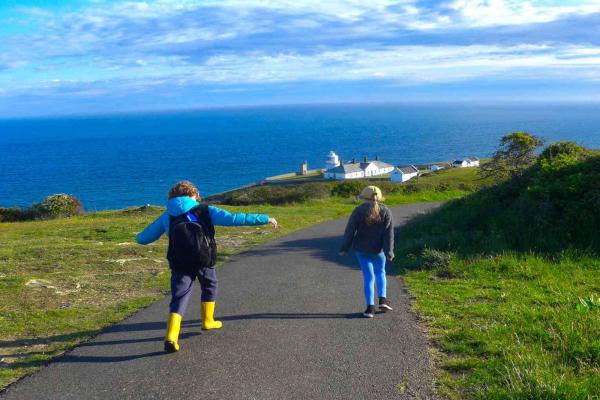 Two children walking near lighthouse