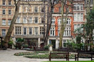 A small area of Postman's park overlooking a row of buildings.