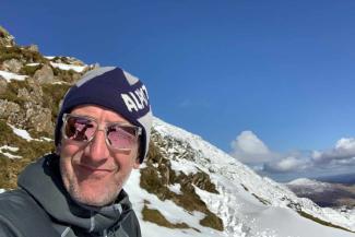 Simon Lightowler out hiking for YHA walks maps on snowy mountain