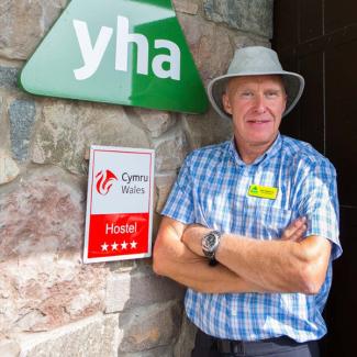 Man standing next to a YHA sign