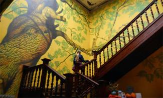 Tree mural on a wall by a staircase