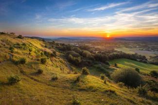 Autumn sunrise over rolling green hills