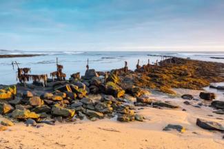 Sandy beach with rocks leading out to the sea