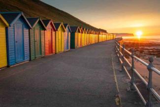 Row of wooden beach huts at sunset