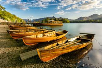 Row of wooden rowing boats on a lake shore