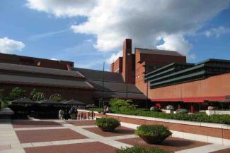 Exterior of a large brick building surrounded by brick paving and planters