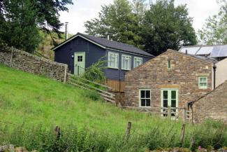 Wooden chalet building next to stone hostel building