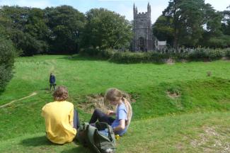 Boy and girl sitting on grass eating a picnic