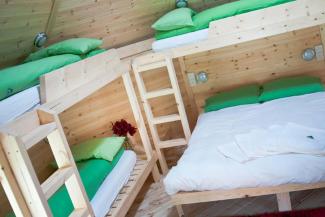 Inside a wooden cabin with a double bed and bunks