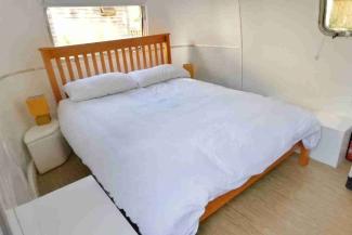 Double bed with white bedding inside an Airstream caravan