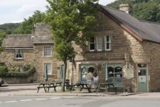 People sitting outside a quaint stone building