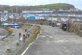 Family of three people walking along a harbour