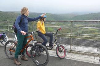 Father and son sitting on bikes on a bridge