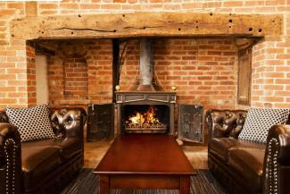 Sofas and a coffee table by a large, open brick fireplace