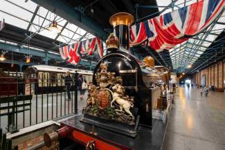 Black steam locomotive inside a museum