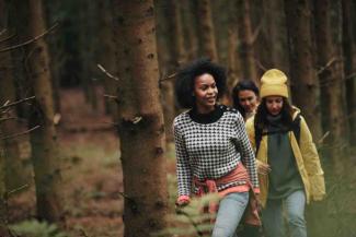 Three women hiking through a forest