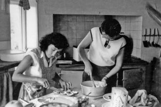 Black and white archive photo of two women cooking in a kitchen