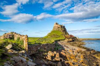 Rocky bay and building on top of a hill overlooking the sea