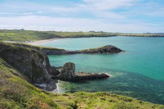 Blue ocean surrounded by green cliffs