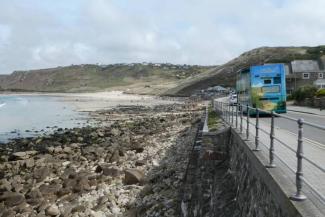 Blue bus driving along the coast