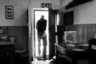 Black and white archive photo of a person walking out a fire exit