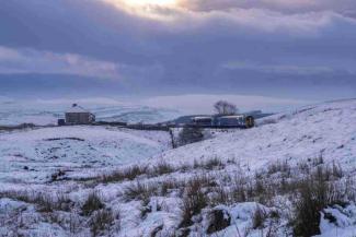 Train travelling through snowy countryside