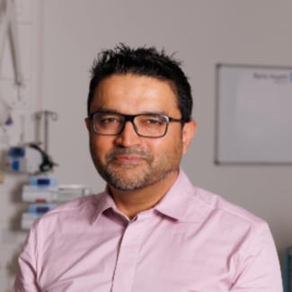 Man wearing glasses and a pink shirt