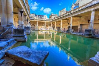 Swimming pool surrounded by stone columns with an open-top roof