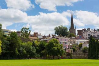 Church with a tall spire overlooking a colourful houses