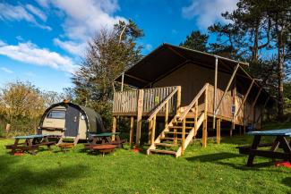 Safari tent and Landpod on a grass field