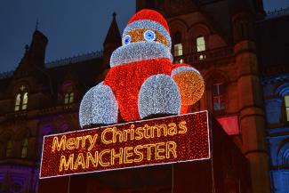 Santa sitting on a building in the city of Manchester  