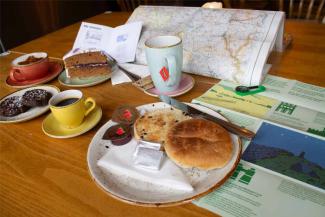 Selection of cakes and drinks on a table with a map at a YHA